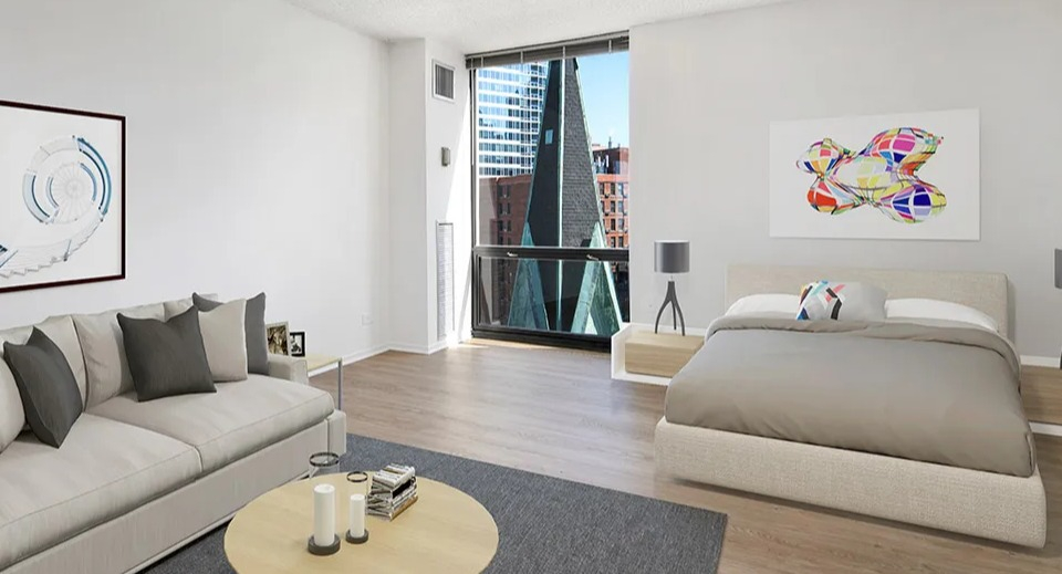 Spacious bedroom with a bed, sofa, large artwork, and floor-to-ceiling windows at 1120 N LaSalle apartments in Chicago
