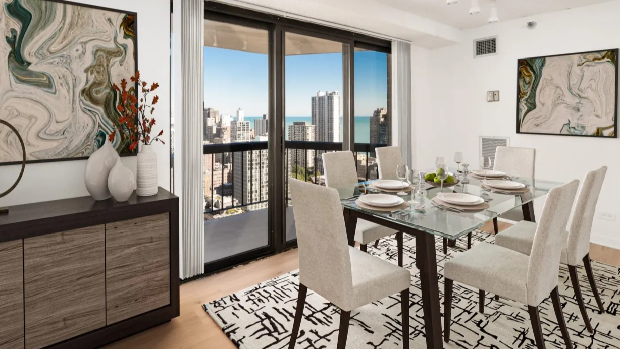 Contemporary dining room with glass table, track lighting, art accents, and sliding doors to a balcony overlooking Chicago from 1133 N Dearborn apartments