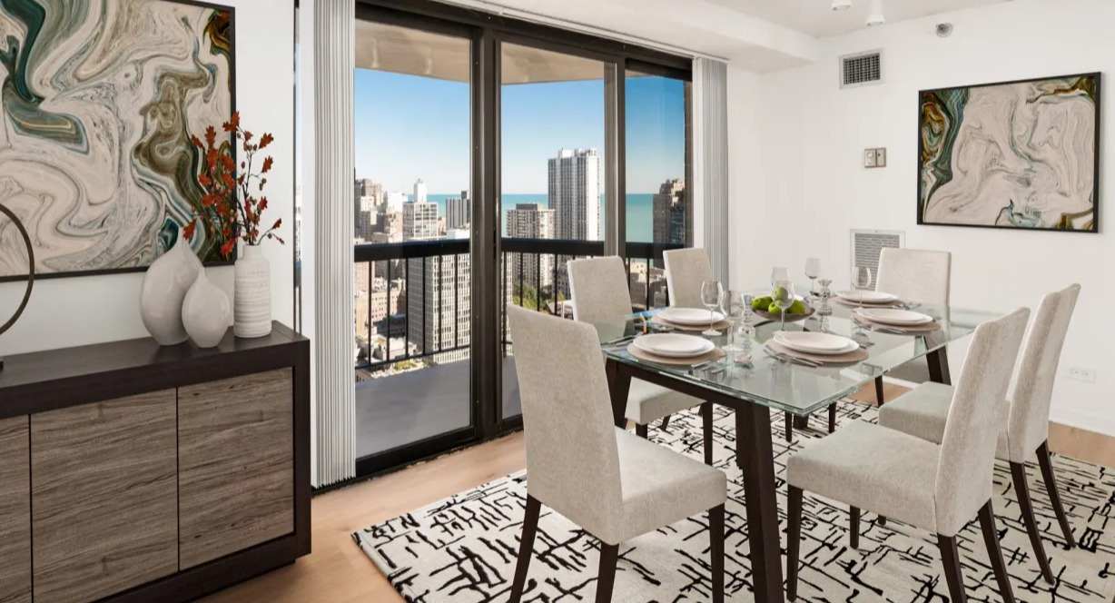 Contemporary dining room with glass table, track lighting, art accents, and sliding doors to a balcony overlooking Chicago from 1133 N Dearborn apartments