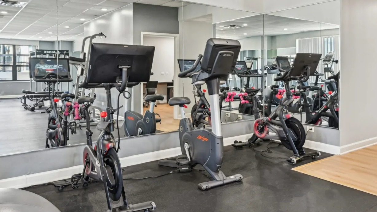 Spin studio corner with stationary bikes, mirrors, and nearby cardio equipment providing a focused workout area at 1133 N Dearborn apartments in Chicago
