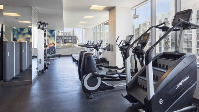 On-site fitness center with cardio machines, strength equipment, and city views at 1225 Old Town Apartments in Chicago