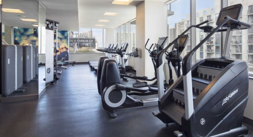 On-site fitness center with cardio machines, strength equipment, and city views at 1225 Old Town Apartments in Chicago