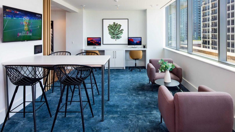 Resident lounge with coworking desks, TVs, and city views at 1225 Old Town Apartments in Chicago, ideal for study, work, or relaxing