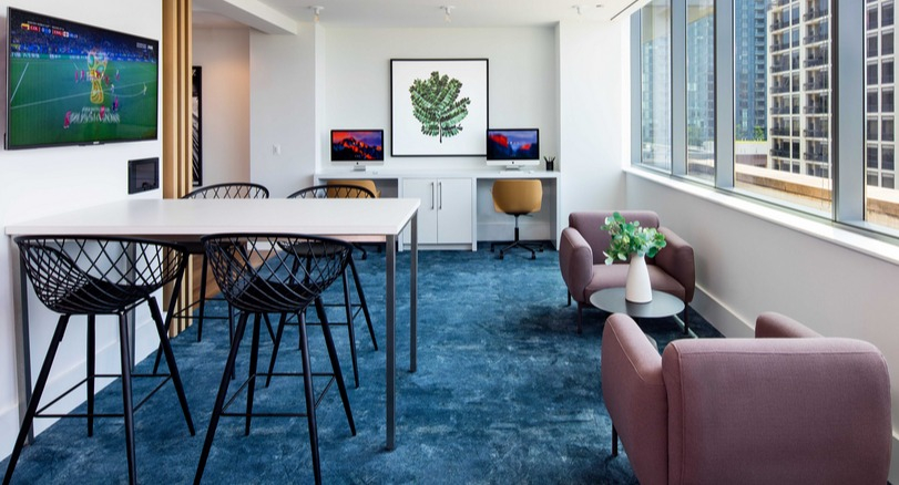 Resident lounge with coworking desks, TVs, and city views at 1225 Old Town Apartments in Chicago, ideal for study, work, or relaxing