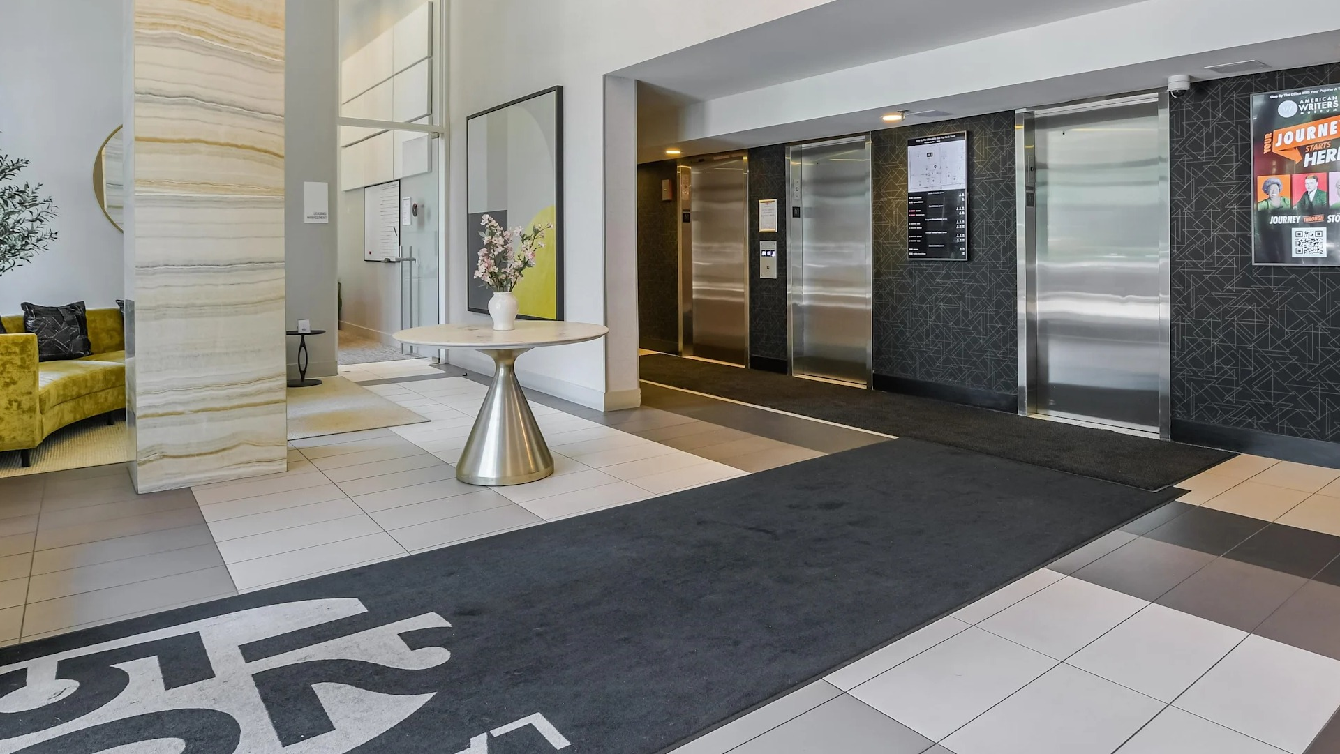 Elevator lobby at 1250 LaSalle with modern light fixtures, patterned accent wall, and convenient access to management and package areas