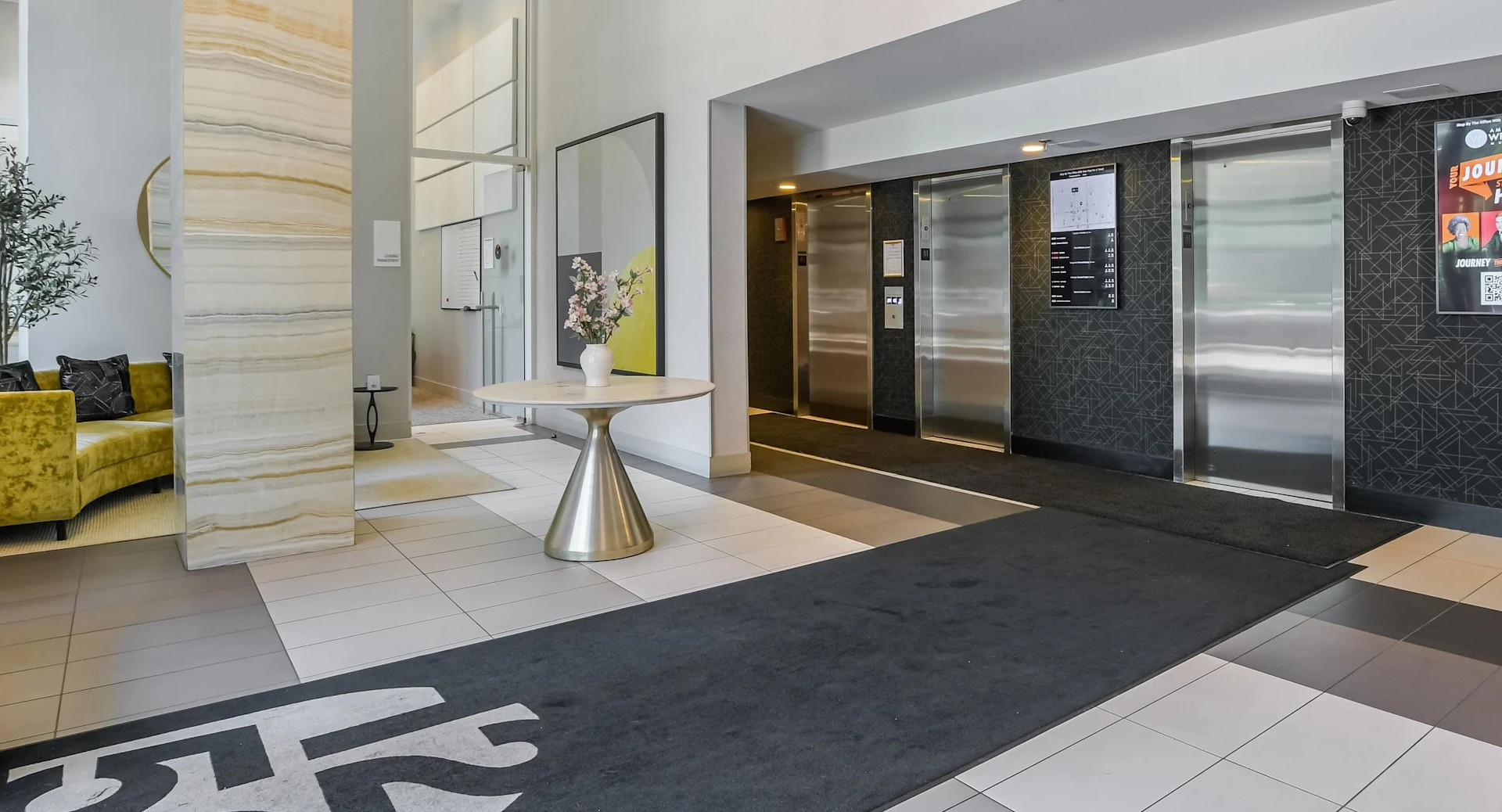Elevator lobby at 1250 LaSalle with modern light fixtures, patterned accent wall, and convenient access to management and package areas