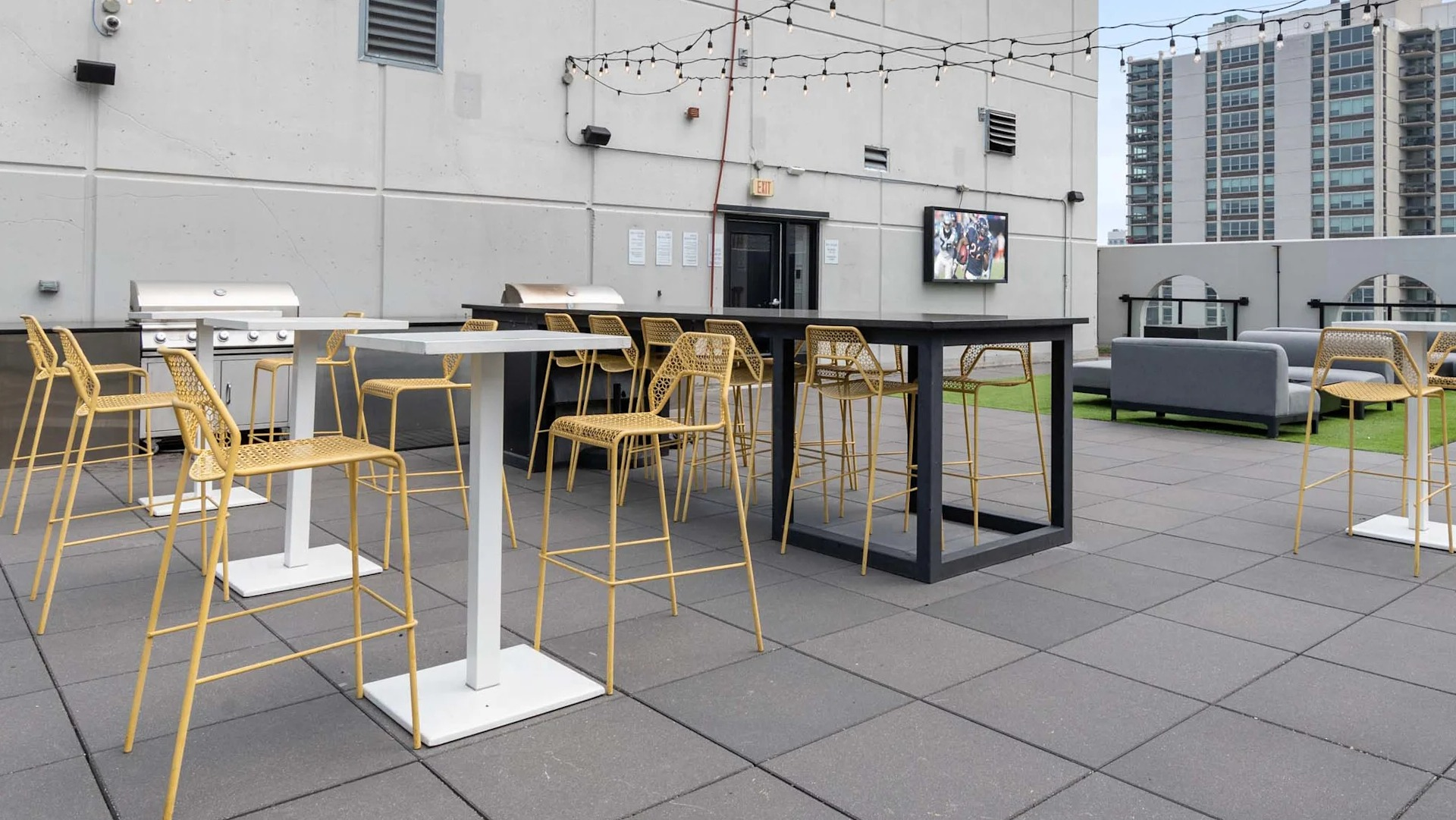 Entertaining rooftop terrace at 1250 LaSalle in Chicago with grilling stations, bar-height tables, and string lights plus lounge zones for gatherings