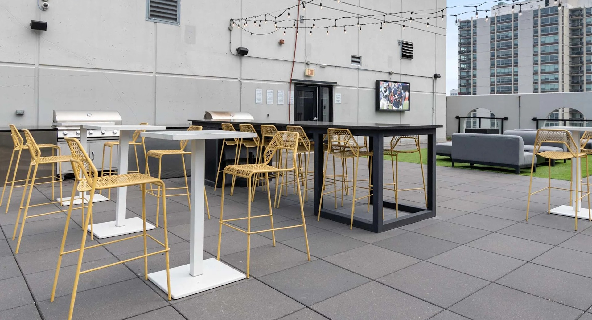 Entertaining rooftop terrace at 1250 LaSalle in Chicago with grilling stations, bar-height tables, and string lights plus lounge zones for gatherings