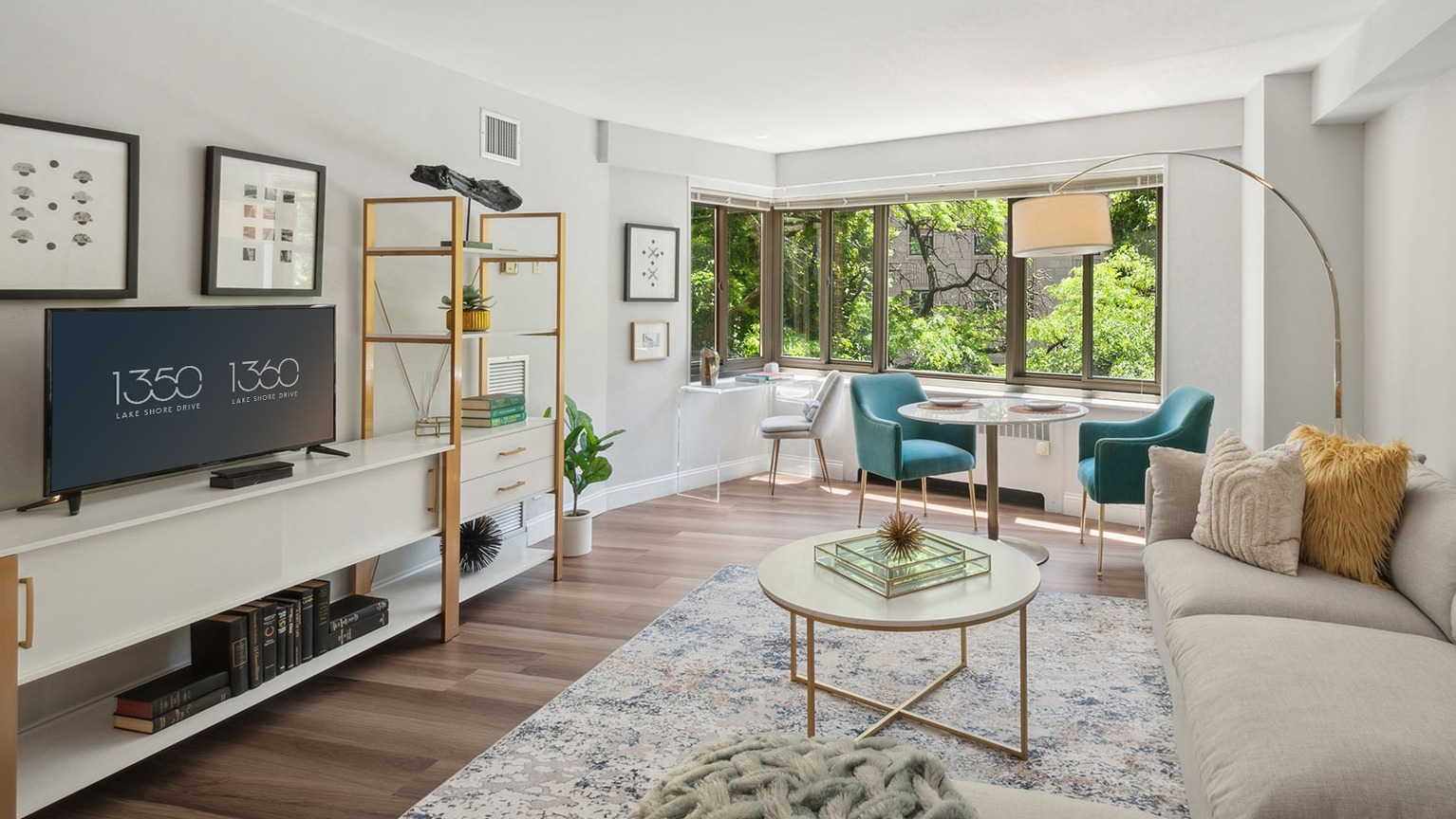 Bright corner living room with bay windows, dining nook, and stylish shelving at 1350–1360 Lake Shore Drive apartments in Chicago
