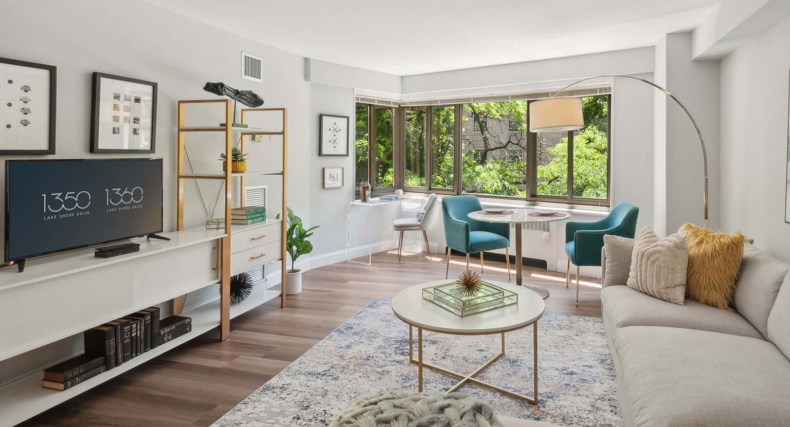 Bright corner living room with bay windows, dining nook, and stylish shelving at 1350–1360 Lake Shore Drive apartments in Chicago