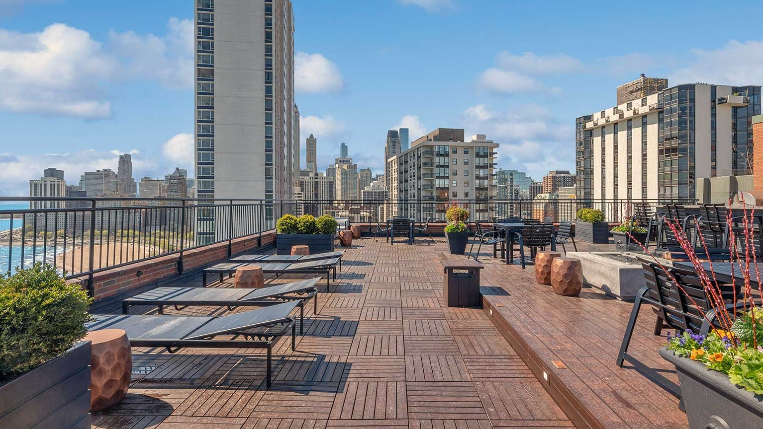Expansive rooftop sundeck with loungers, seating areas, and panoramic Chicago skyline and Lake Michigan views at 1350–1360 Lake Shore Drive apartments