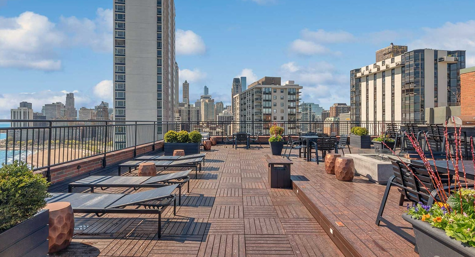 Expansive rooftop sundeck with loungers, seating areas, and panoramic Chicago skyline and Lake Michigan views at 1350–1360 Lake Shore Drive apartments