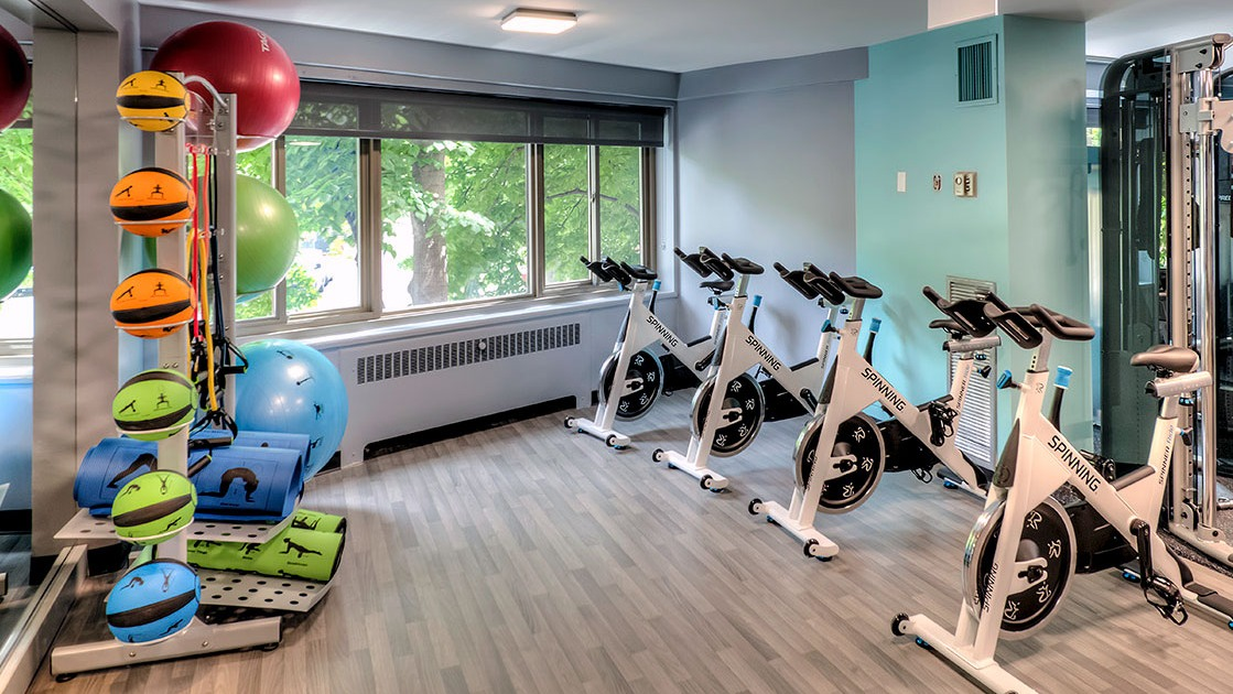 Light-filled fitness studio with rows of Spinning bikes, yoga mats, and stability balls at 1350-1360 Lake Shore Drive apartments in Chicago
