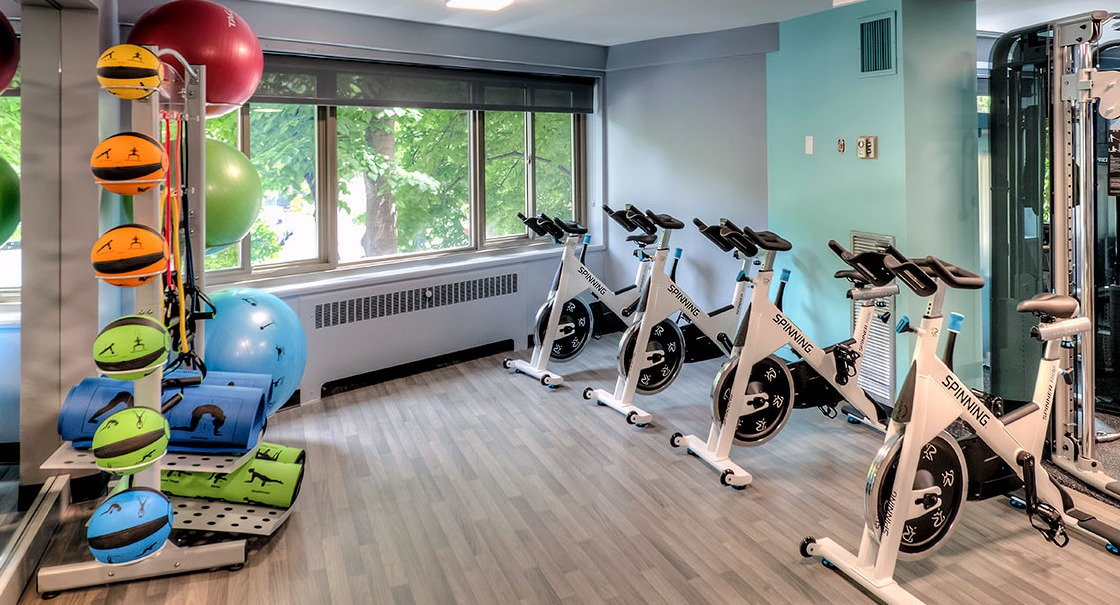 Light-filled fitness studio with rows of Spinning bikes, yoga mats, and stability balls at 1350-1360 Lake Shore Drive apartments in Chicago