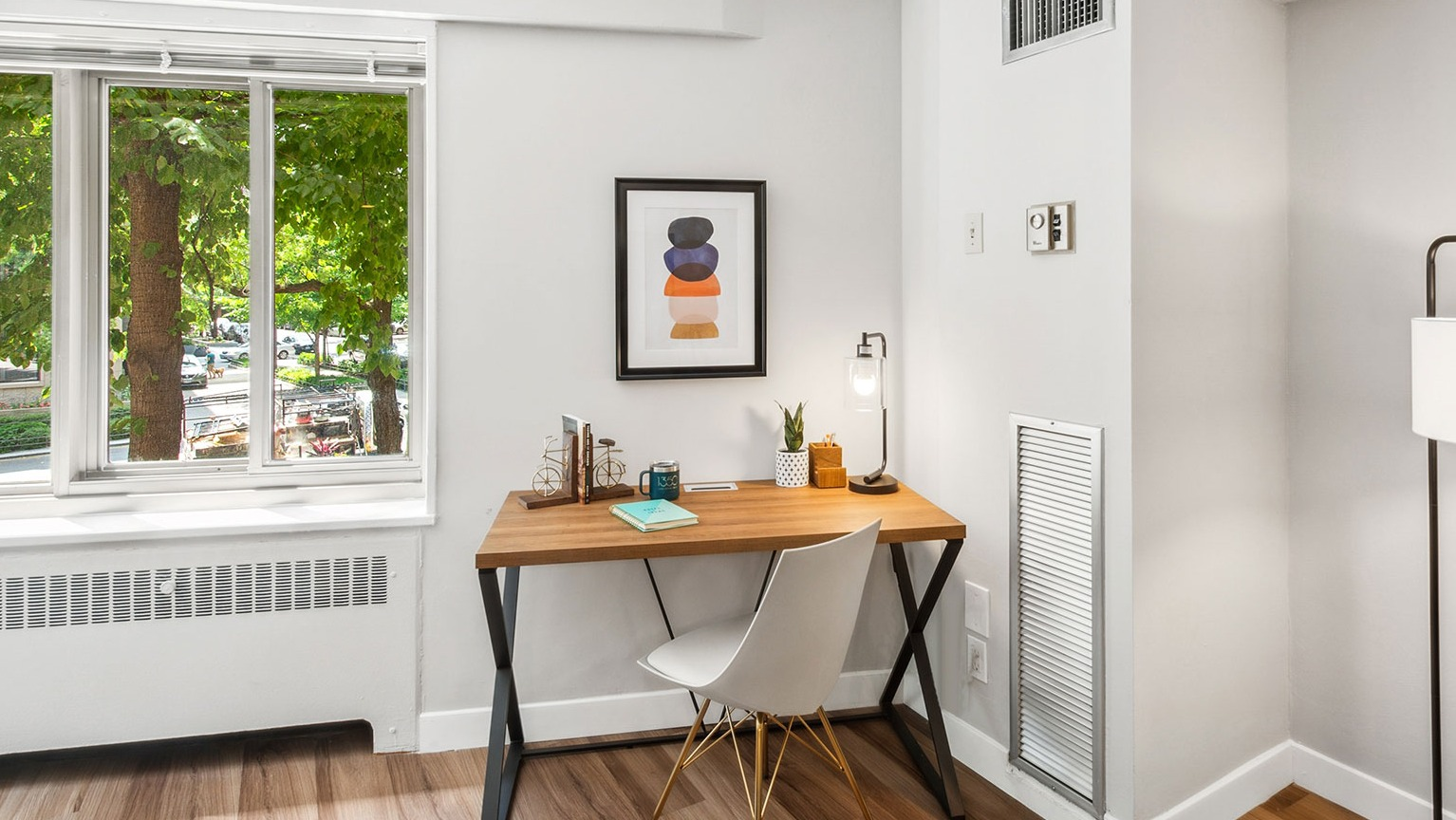 In-home workspace with wood desk, modern chair, and bright window views at 1350–1360 Lake Shore Drive apartments in Chicago