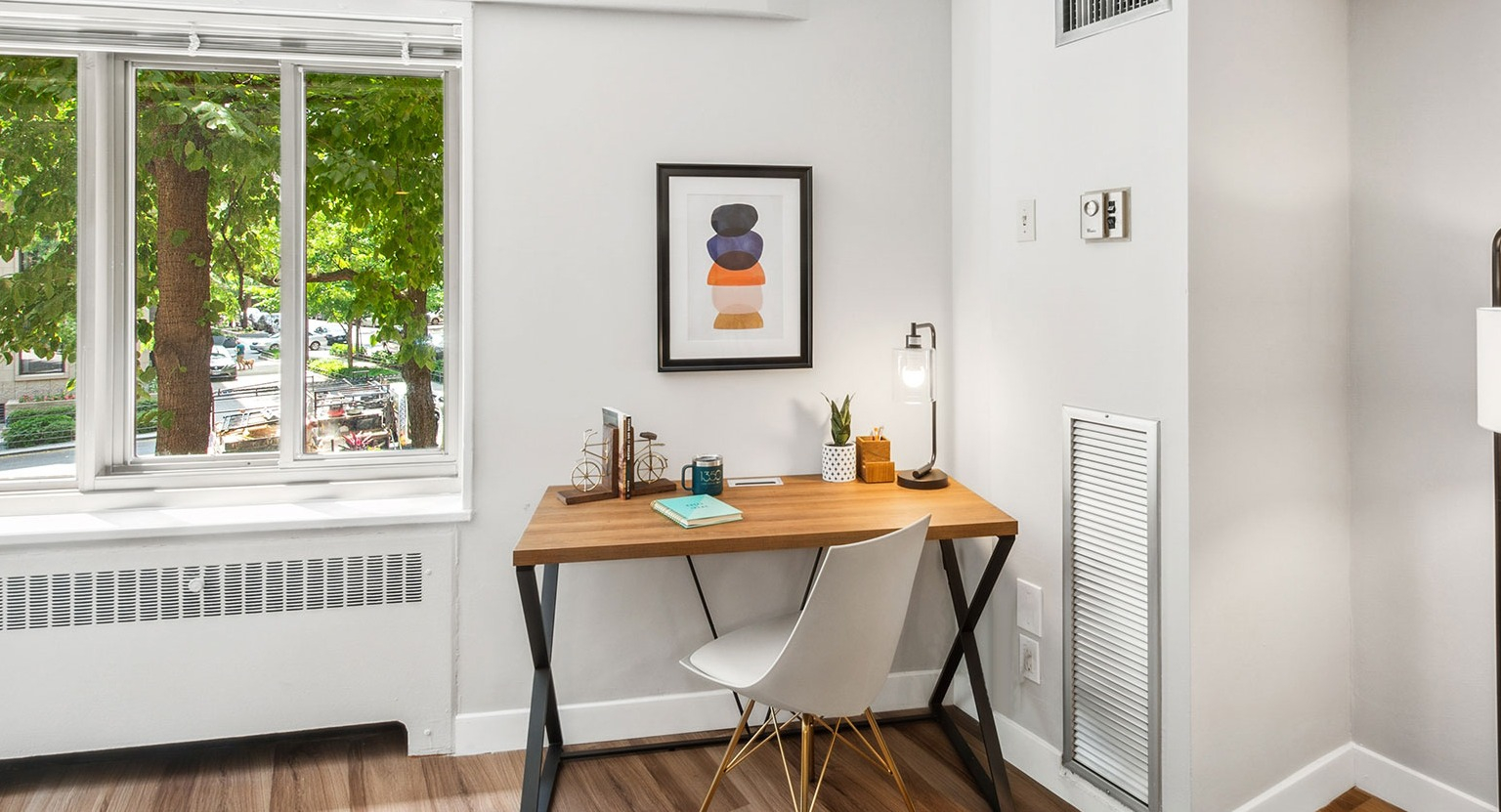 In-home workspace with wood desk, modern chair, and bright window views at 1350–1360 Lake Shore Drive apartments in Chicago