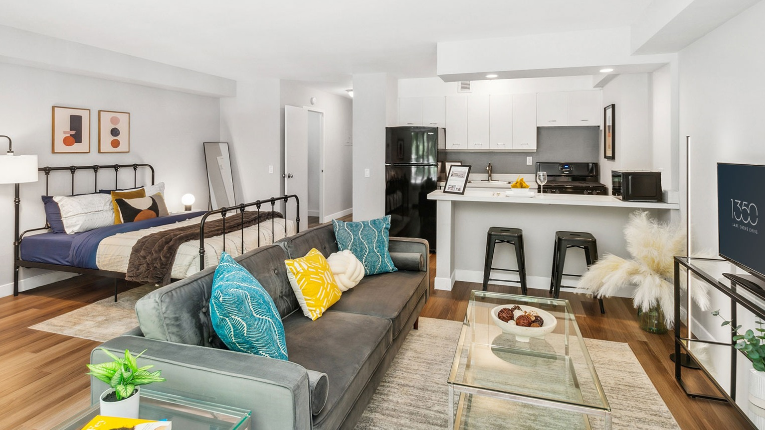 Bright open-concept studio with living area, bed, breakfast bar, and modern kitchen at 1350–1360 Lake Shore Drive apartments in Chicago