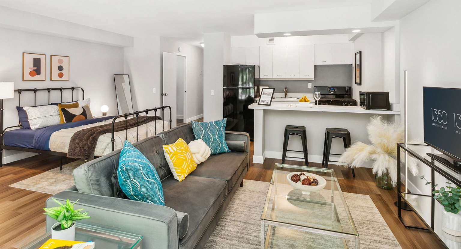 Bright open-concept studio with living area, bed, breakfast bar, and modern kitchen at 1350–1360 Lake Shore Drive apartments in Chicago