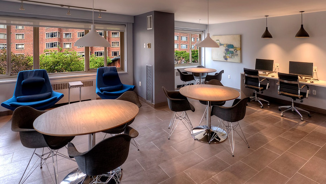 Resident lounge and business center with café tables, lounge chairs, desktop computers, and printer at 1350–1360 Lake Shore Drive apartments in Chicago