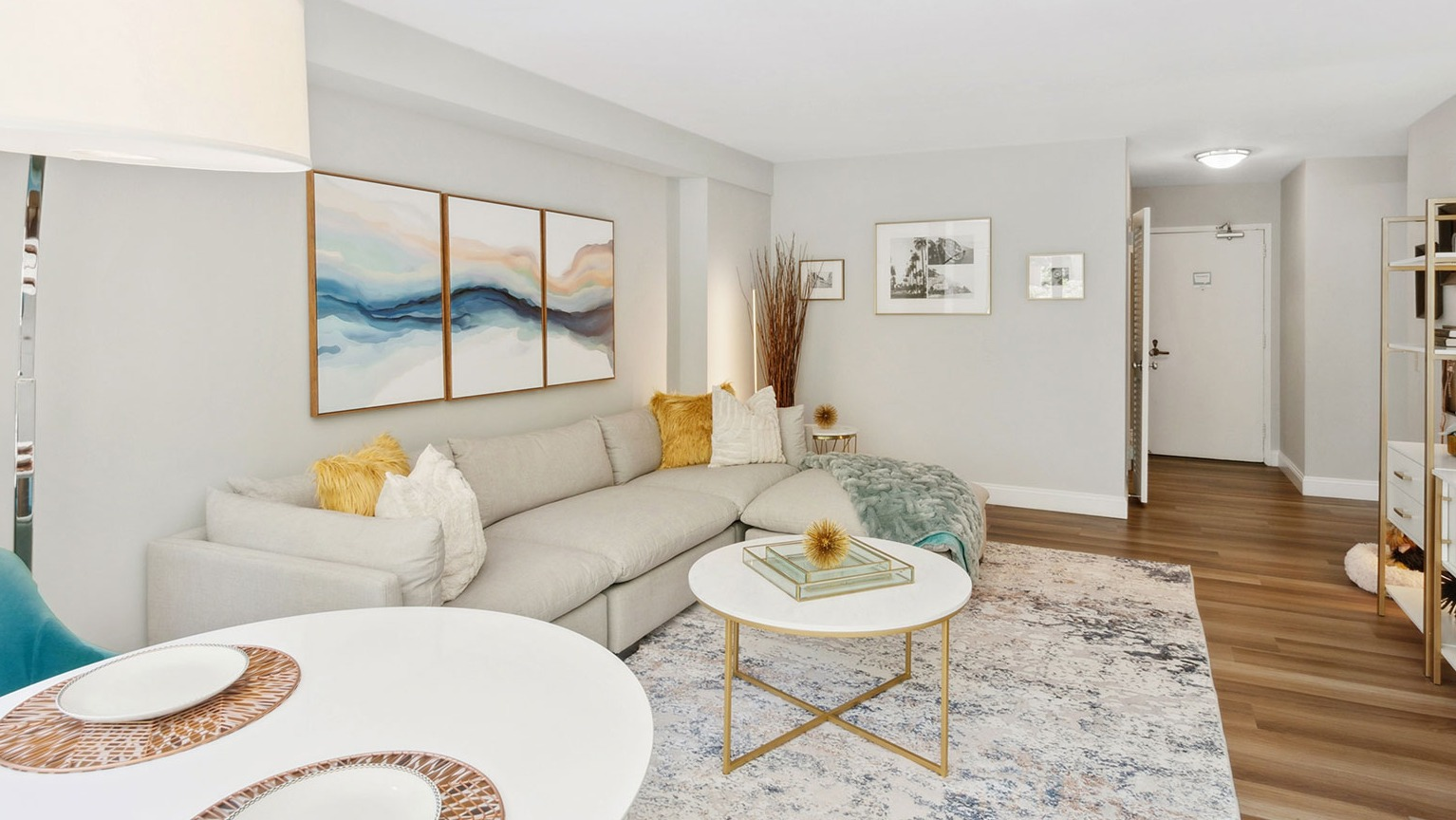 Spacious living room with large sectional sofa, modern shelving, and dining area accents at 1350–1360 Lake Shore Drive apartments in Chicago