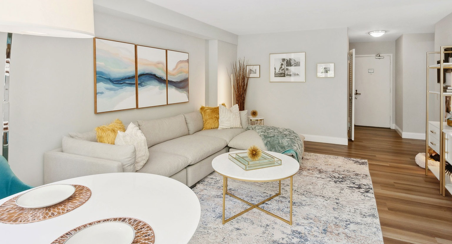 Spacious living room with large sectional sofa, modern shelving, and dining area accents at 1350–1360 Lake Shore Drive apartments in Chicago