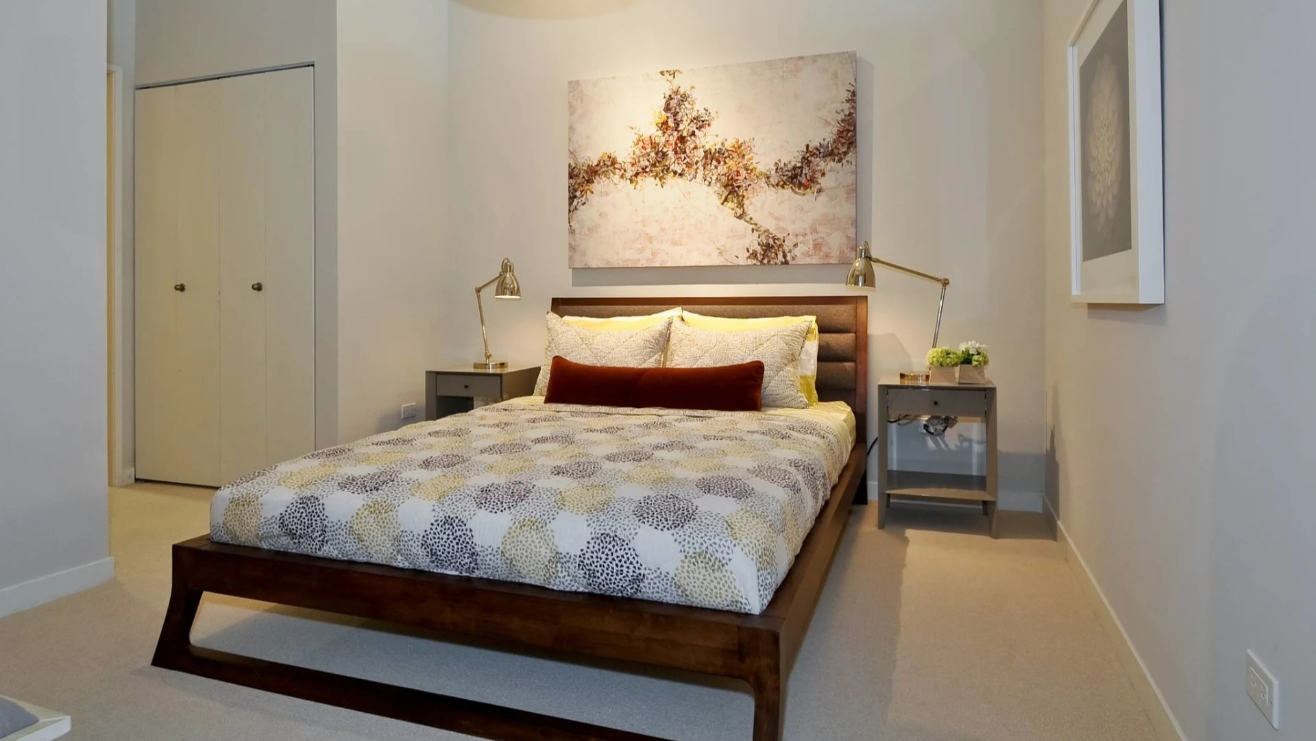 Cozy bedroom at 13thirteen Randolph Street Lofts with wood platform bed, neutral bedding, tall ceilings, and matching nightstands for comfortable Chicago living