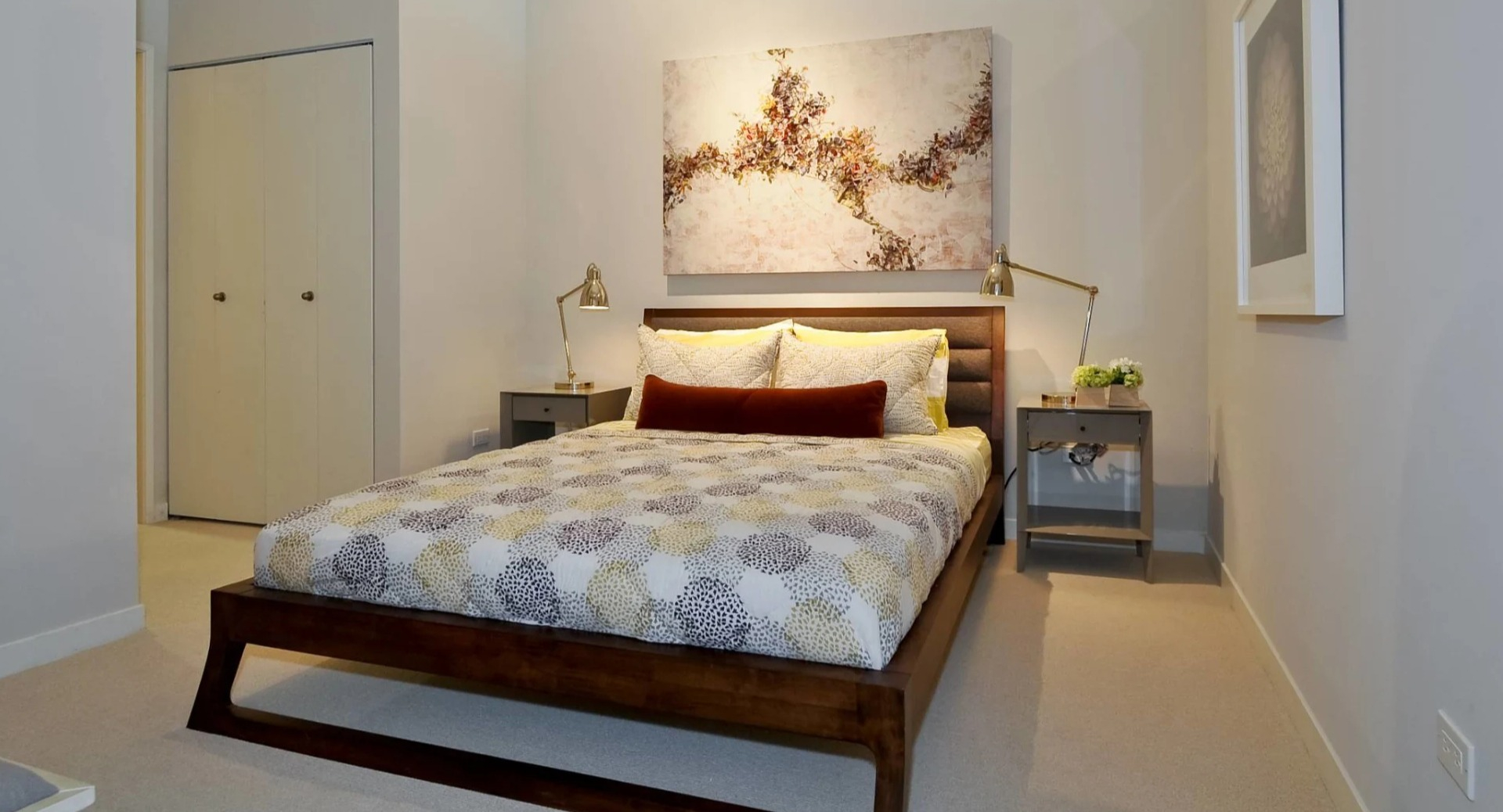 Cozy bedroom at 13thirteen Randolph Street Lofts with wood platform bed, neutral bedding, tall ceilings, and matching nightstands for comfortable Chicago living