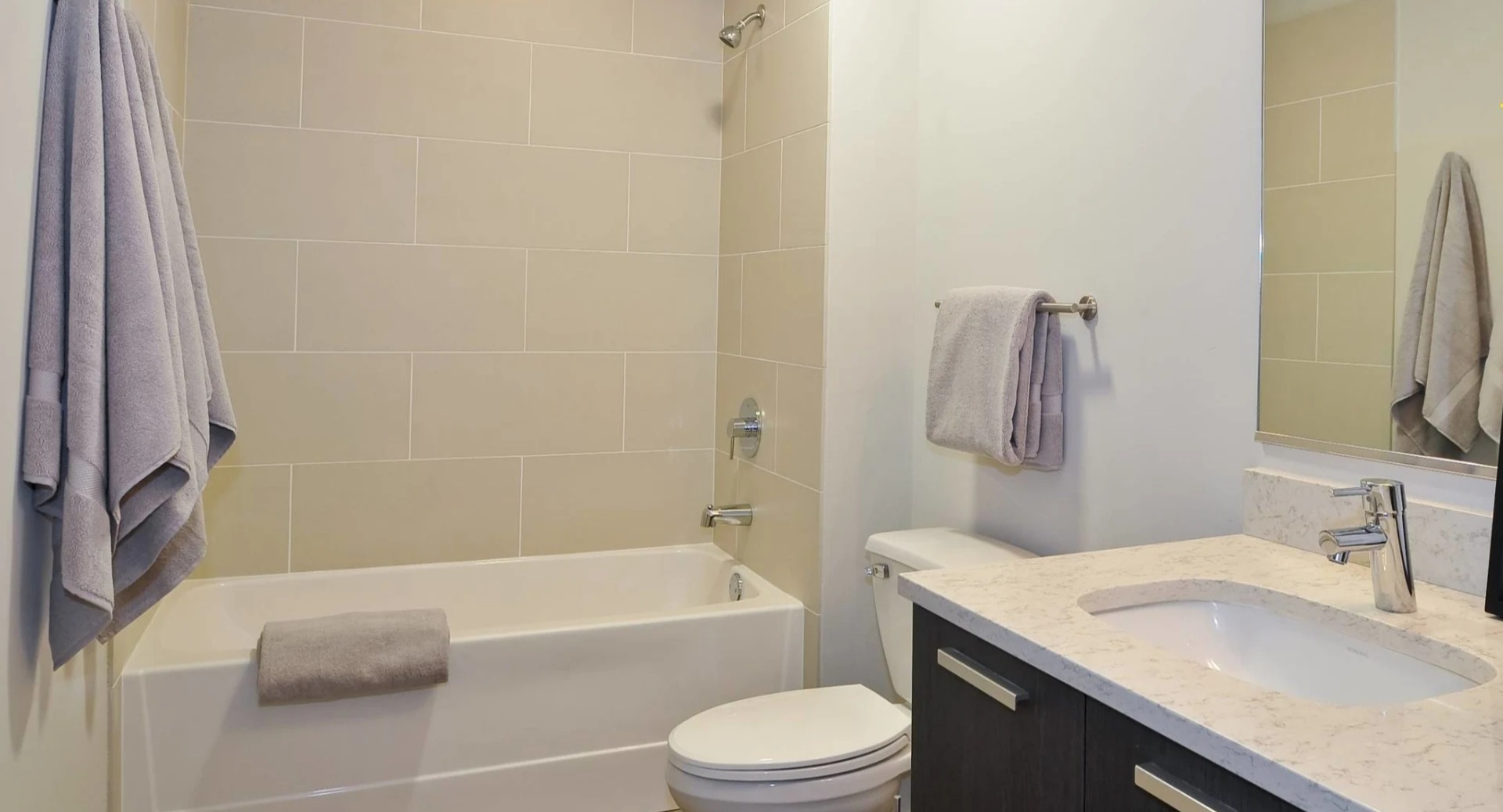 Modern bathroom at 13thirteen Randolph Street Lofts with large tiled tub-shower, quartz vanity, and soft lighting for a clean, relaxing feel in Chicago