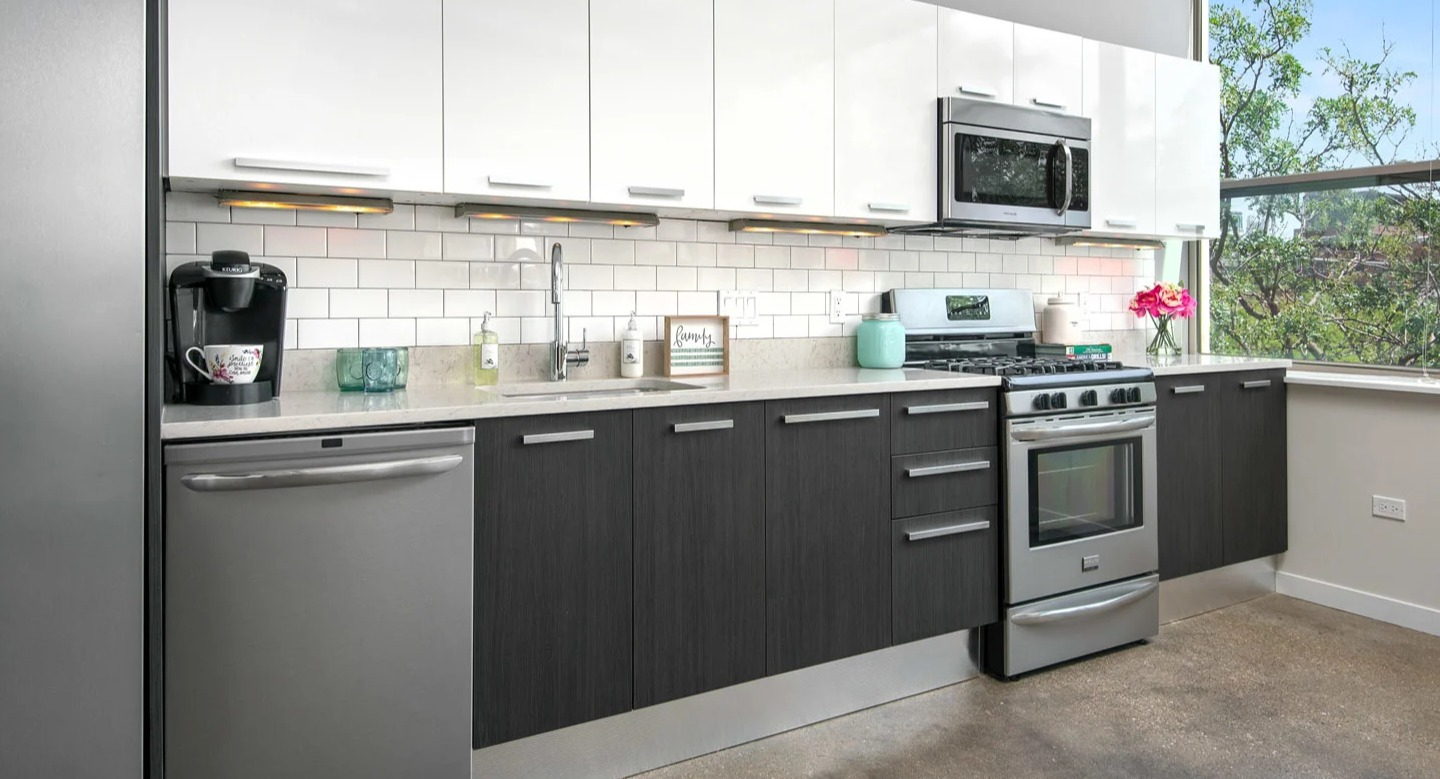 Modern kitchen at 13thirteen Randolph Street Lofts with white subway tile, two-tone cabinets, stainless appliances, and bright window light for Chicago renters