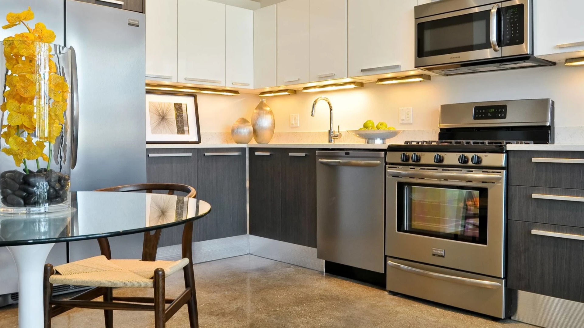 Upgraded kitchen at 13thirteen Randolph Street Lofts featuring stainless appliances, quartz counters, and a cozy dining nook for comfortable Chicago living