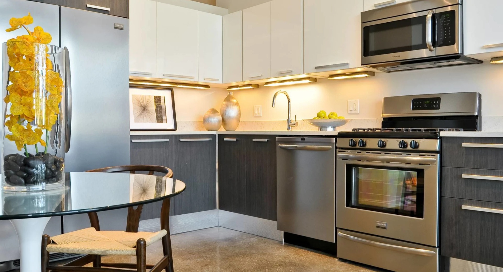 Upgraded kitchen at 13thirteen Randolph Street Lofts featuring stainless appliances, quartz counters, and a cozy dining nook for comfortable Chicago living