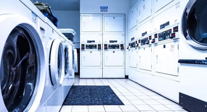 Clean and convenient on-site laundry room with multiple washing machines and dryers for resident use at 14 West Elm Apartments in Chicago
