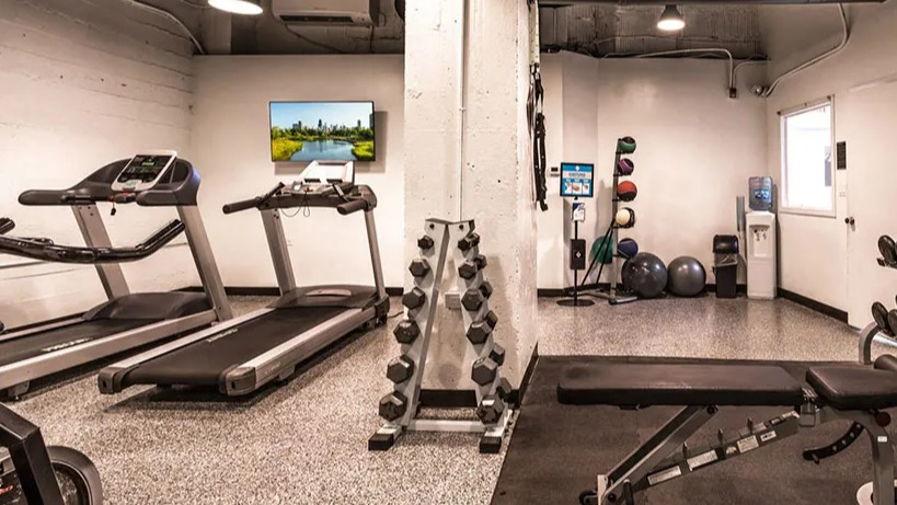 Well-equipped modern fitness center with treadmills, free weights, and exercise machines for residents at 14 West Elm Apartments in Chicago