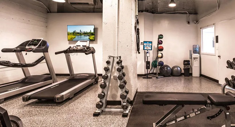 Well-equipped modern fitness center with treadmills, free weights, and exercise machines for residents at 14 West Elm Apartments in Chicago