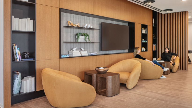 Cozy library nook with built-in shelves, lounge chairs, and warm wood accents for quiet work or reading at 1400 Wabash apartments in Chicago