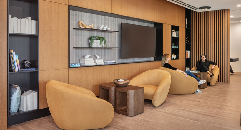 Cozy library nook with built-in shelves, lounge chairs, and warm wood accents for quiet work or reading at 1400 Wabash apartments in Chicago