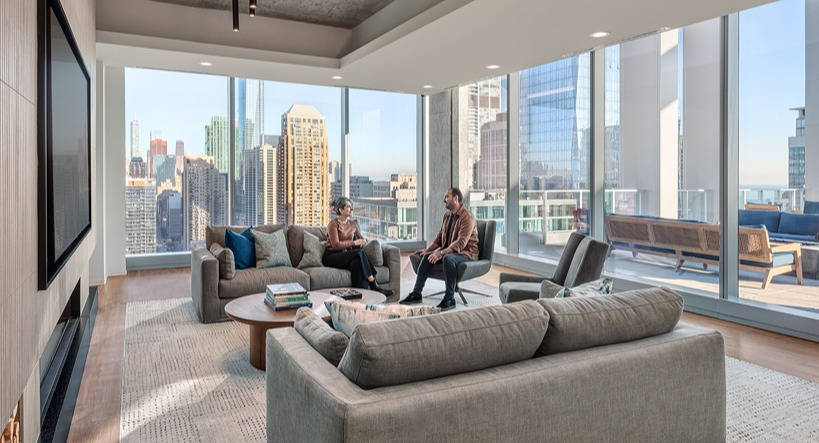 Stylish resident lounge with plush sofas, large TV wall, designer lighting, and floor-to-ceiling windows opening to a terrace at 1400 Wabash in Chicago