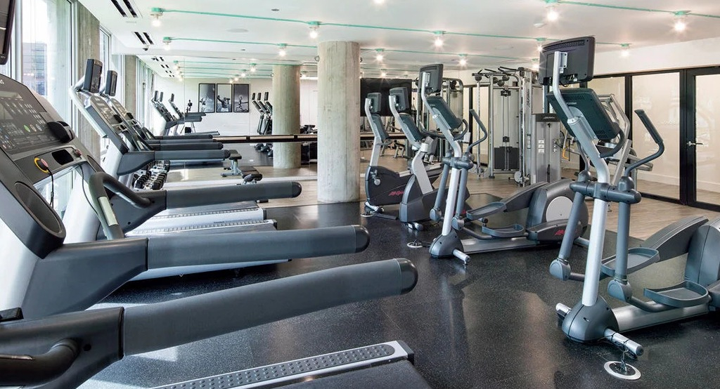 Extensive cardio gym at 1401 S. State Apartments in Chicago, featuring numerous treadmills, ellipticals, and strength machines
