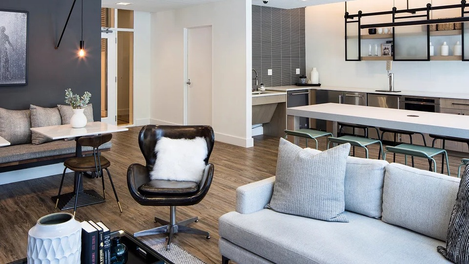 Modern resident lounge at 1401 S. State Apartments in Chicago, featuring stylish seating, a communal kitchen, and elegant decor