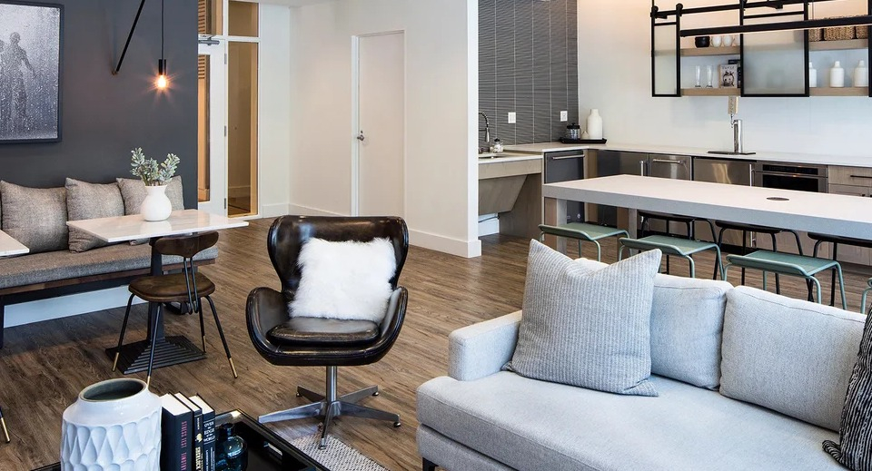 Modern resident lounge at 1401 S. State Apartments in Chicago, featuring stylish seating, a communal kitchen, and elegant decor