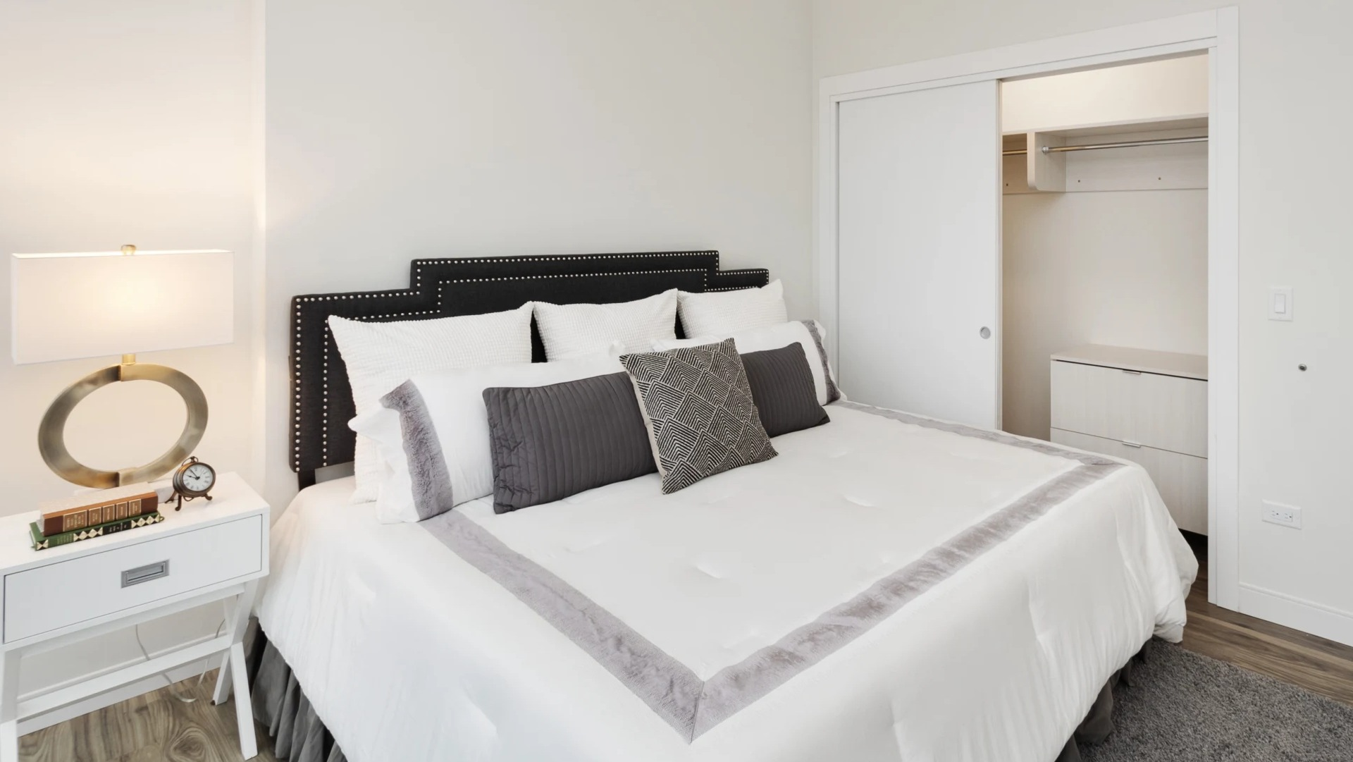 Cozy primary bedroom with upholstered headboard, neutral palette, and sliding-door closet at 1407 on Michigan apartments in Chicago