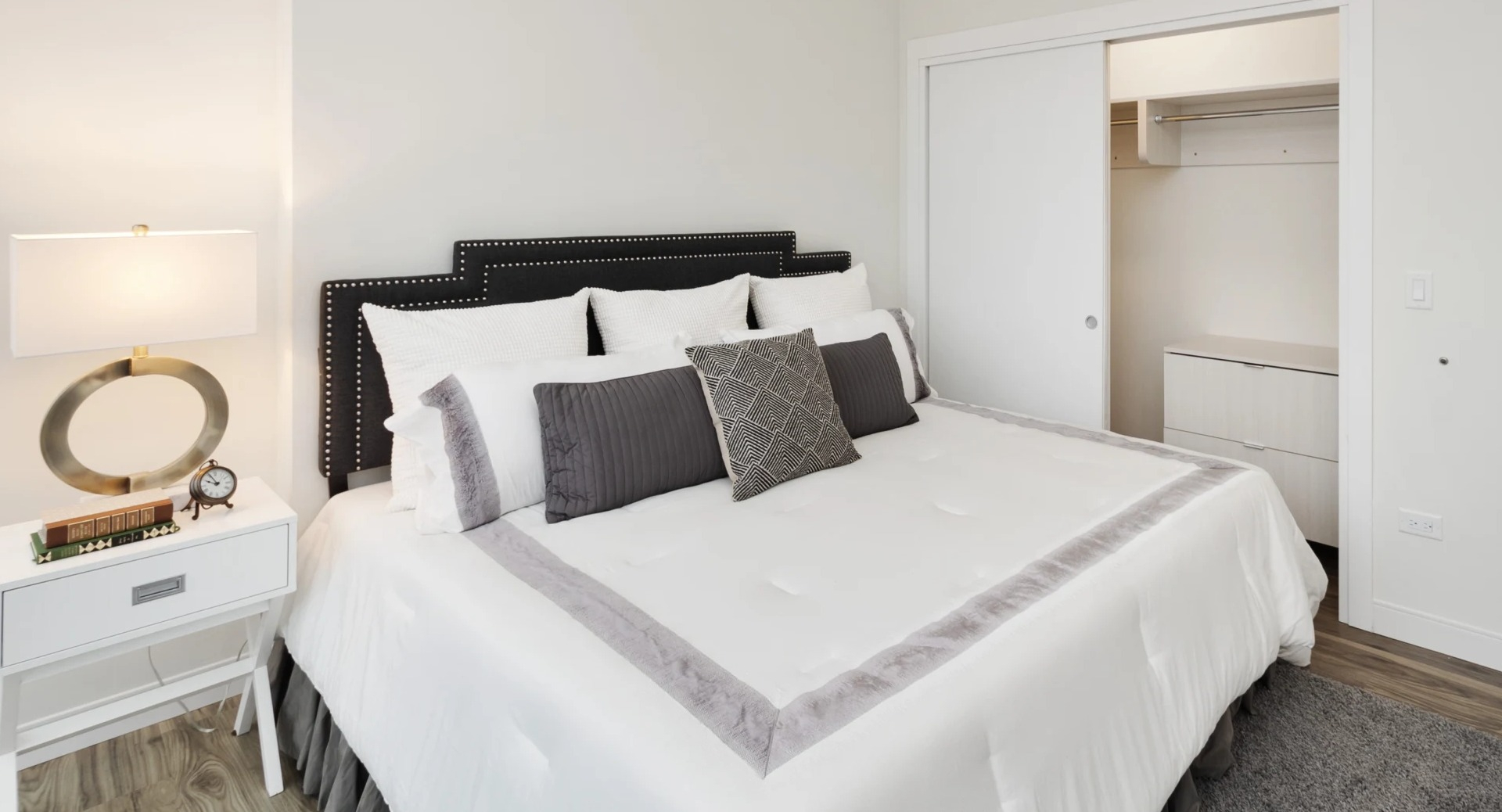 Cozy primary bedroom with upholstered headboard, neutral palette, and sliding-door closet at 1407 on Michigan apartments in Chicago