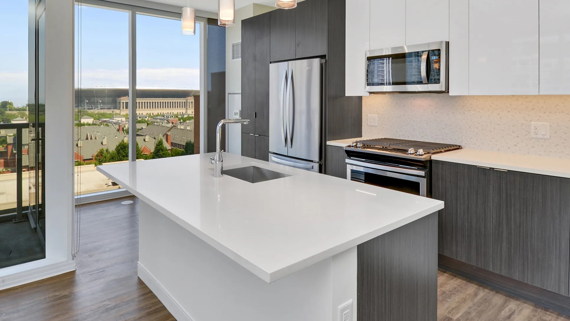 Modern kitchen with sleek cabinets, stainless steel appliances, and a large quartz island overlooking city views at 1407 on Michigan in Chicago