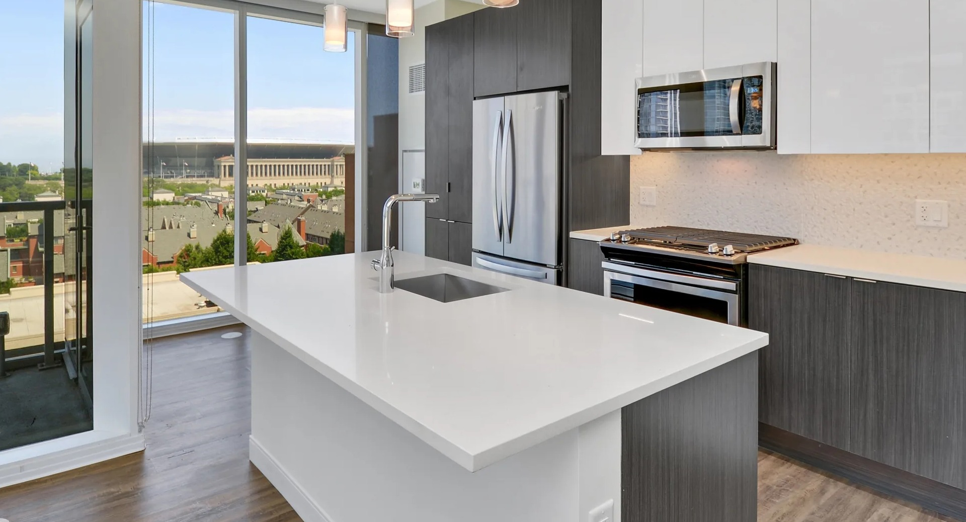 Modern kitchen with sleek cabinets, stainless steel appliances, and a large quartz island overlooking city views at 1407 on Michigan in Chicago