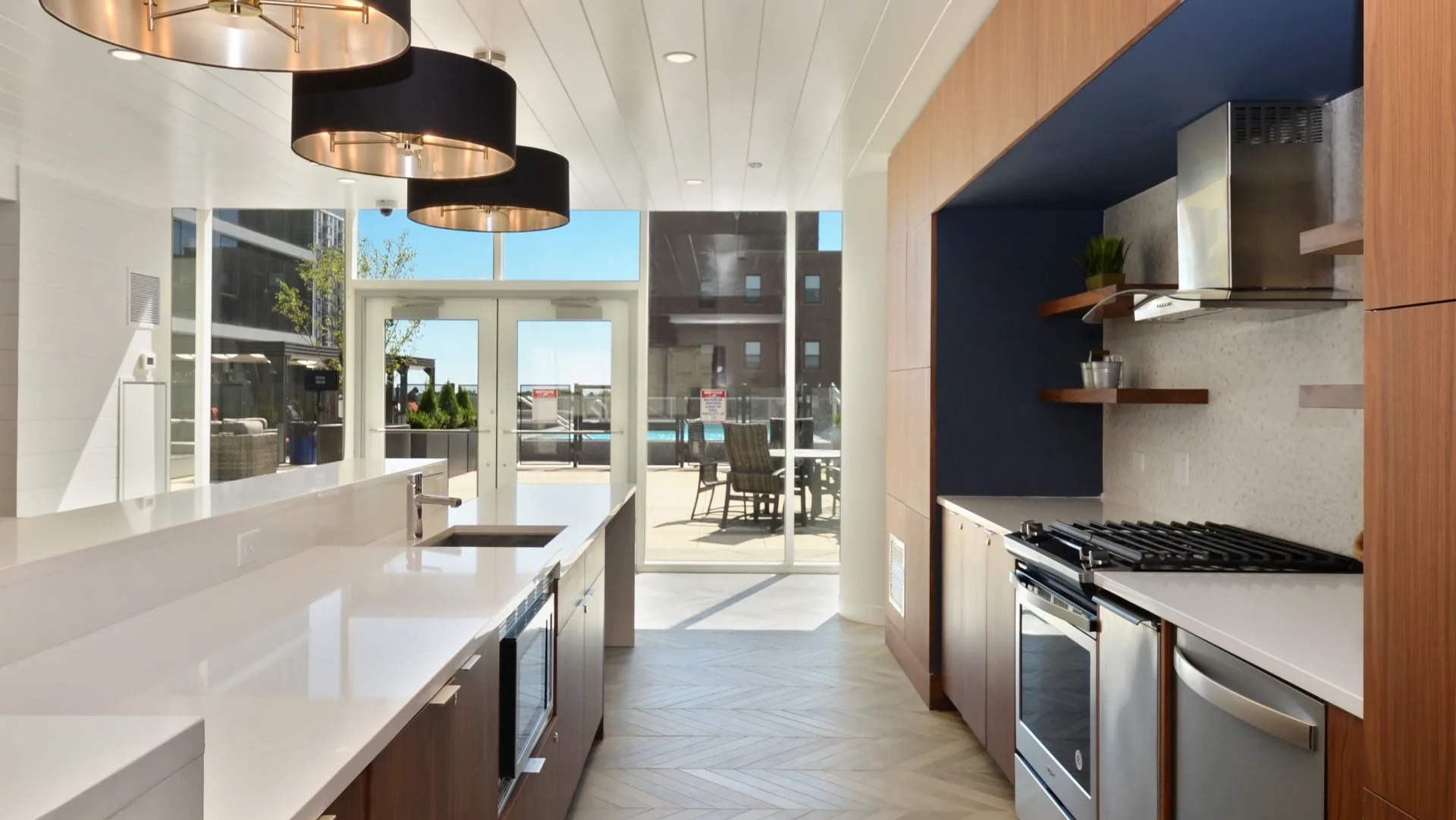 Resident entertainment kitchen with long counter, pendant lighting, and patio access at 1407 on Michigan apartments in Chicago