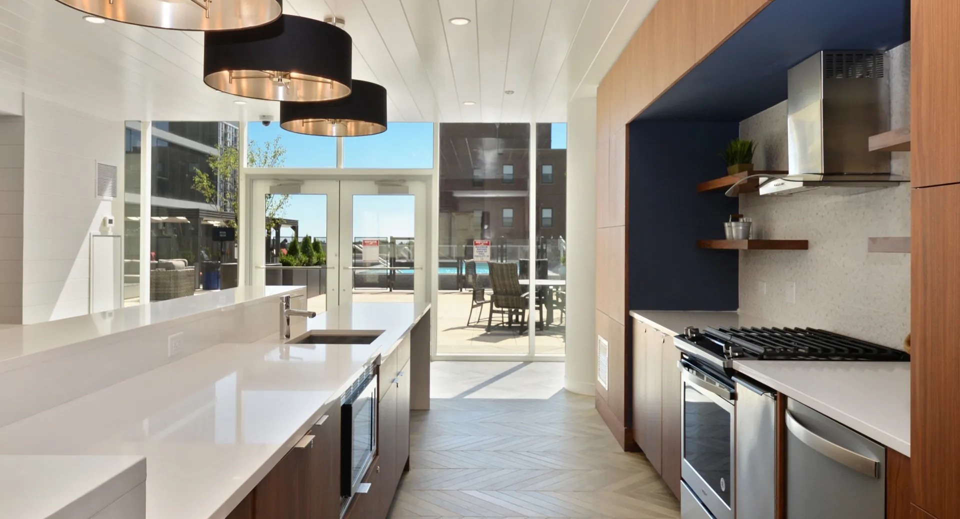 Resident entertainment kitchen with long counter, pendant lighting, and patio access at 1407 on Michigan apartments in Chicago