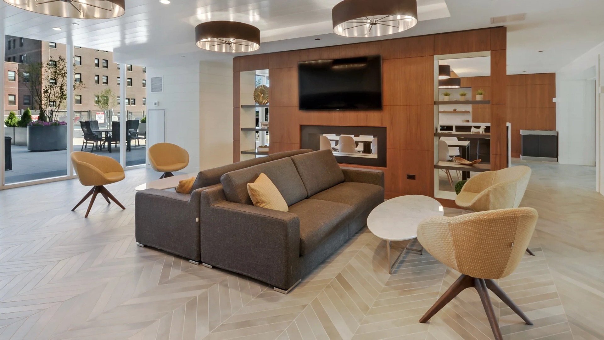 Bright resident lounge with fireplace, modern seating, and access to an outdoor terrace at 1407 on Michigan apartments in Chicago