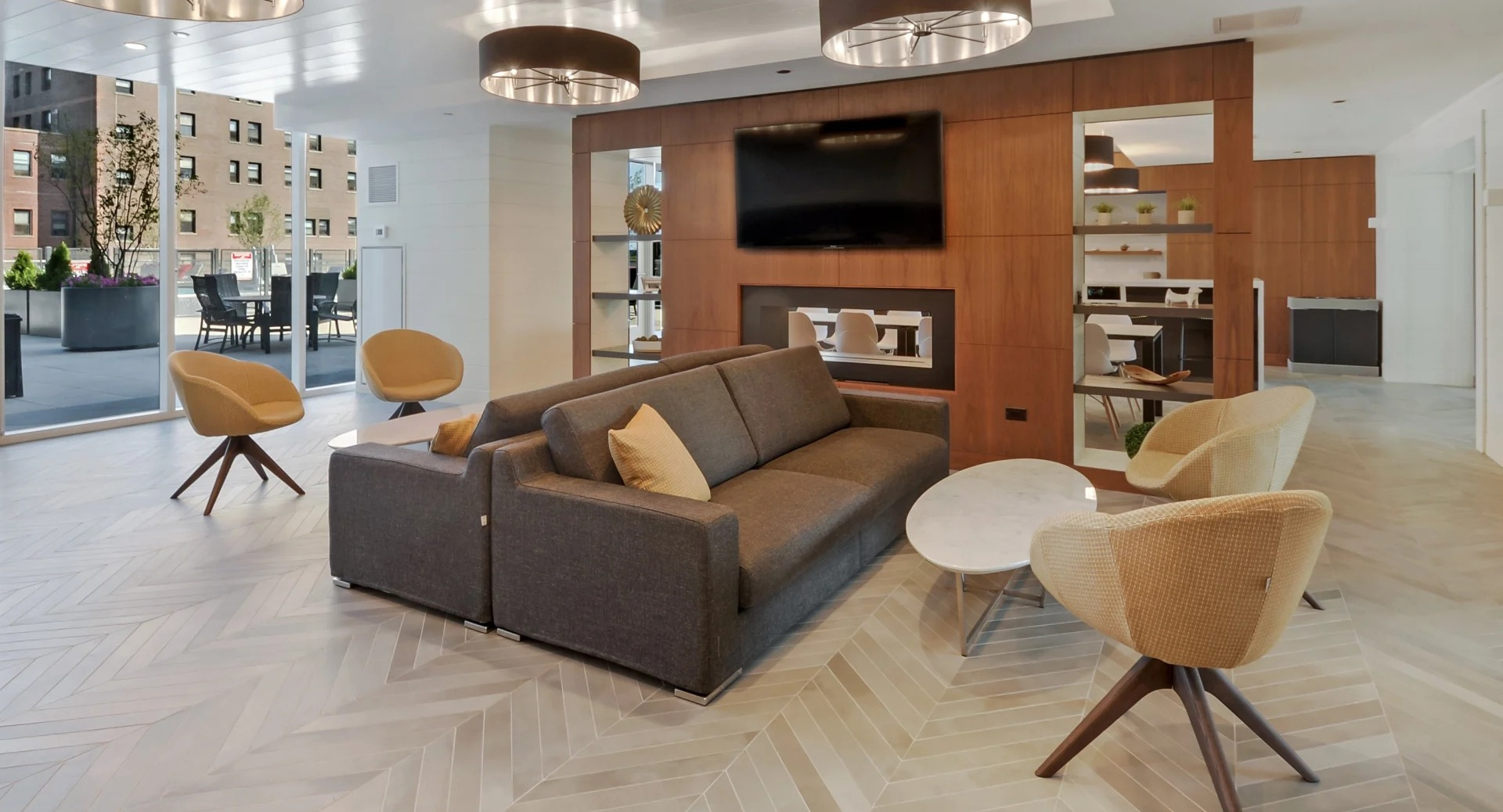 Bright resident lounge with fireplace, modern seating, and access to an outdoor terrace at 1407 on Michigan apartments in Chicago