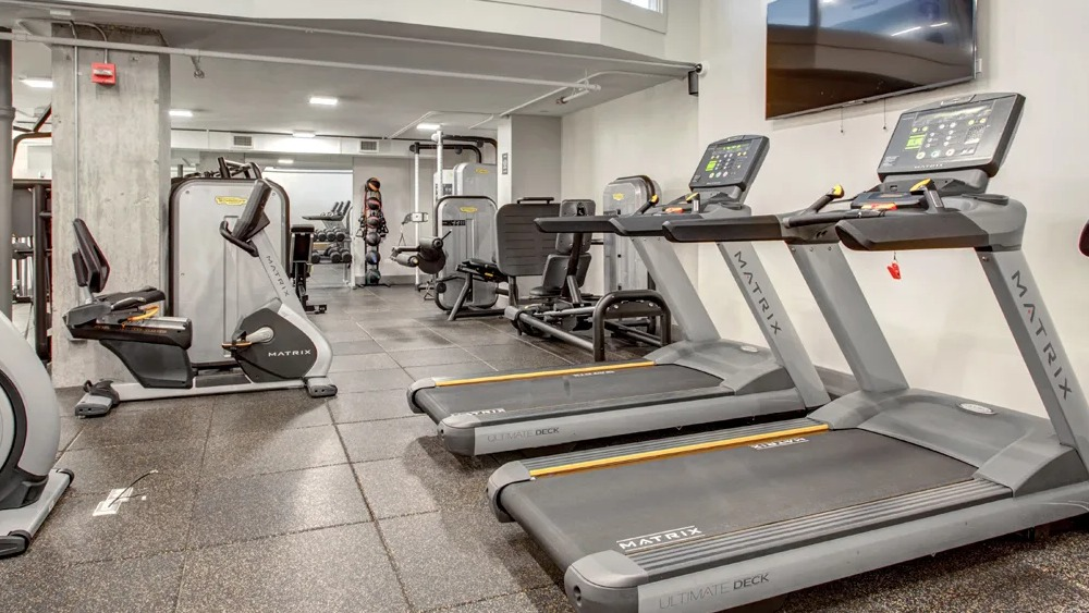 Cardio room with treadmills, ellipticals and strength machines on durable flooring at 180 North Jefferson apartments in Chicago