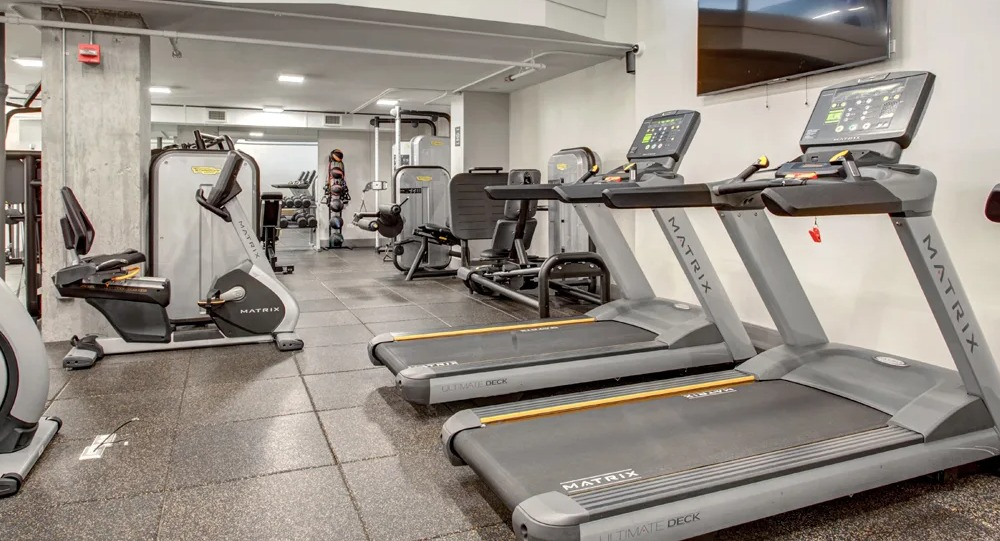 Cardio room with treadmills, ellipticals and strength machines on durable flooring at 180 North Jefferson apartments in Chicago